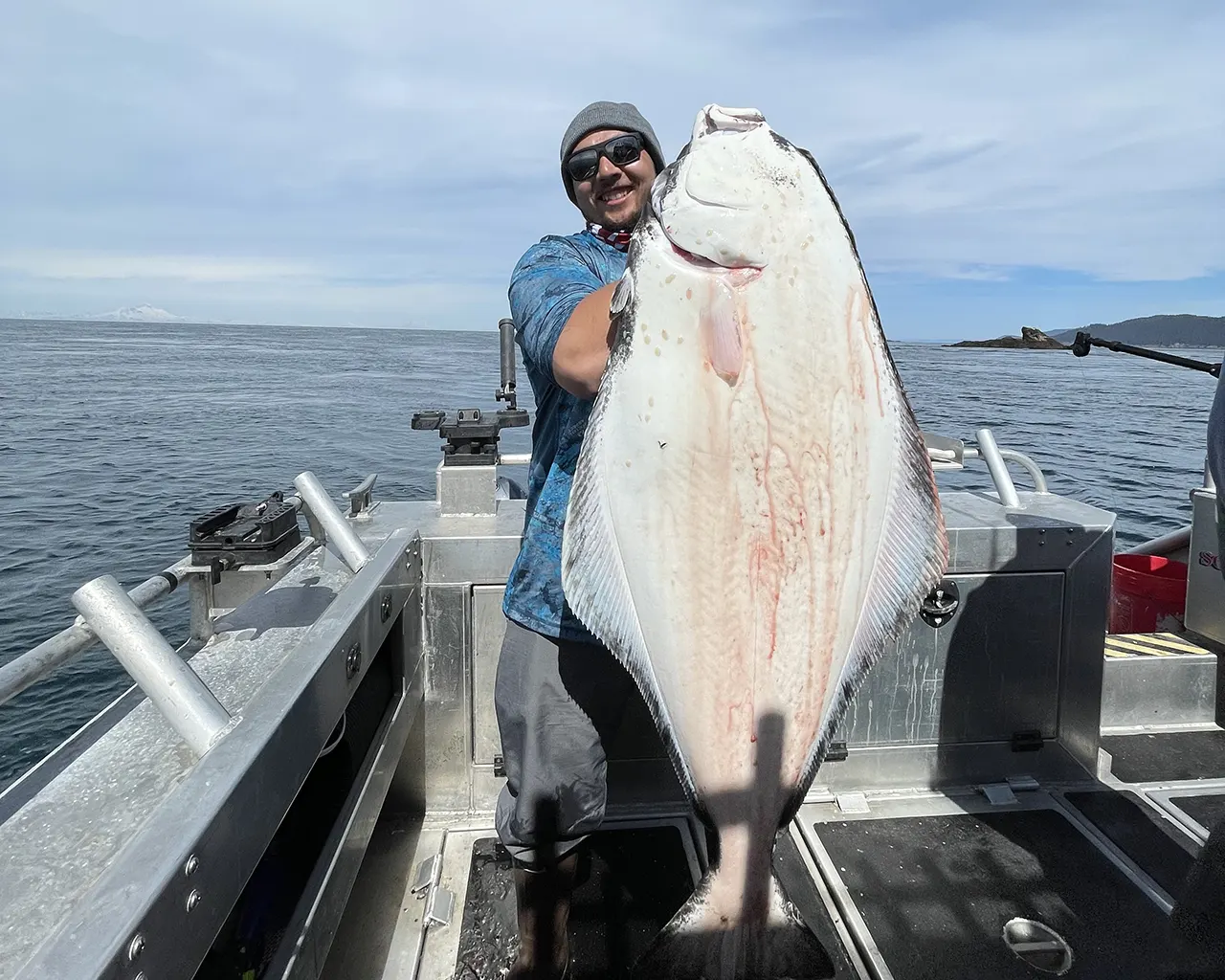 Captain Creig Garret holds a halibut estimated at 110 lbs